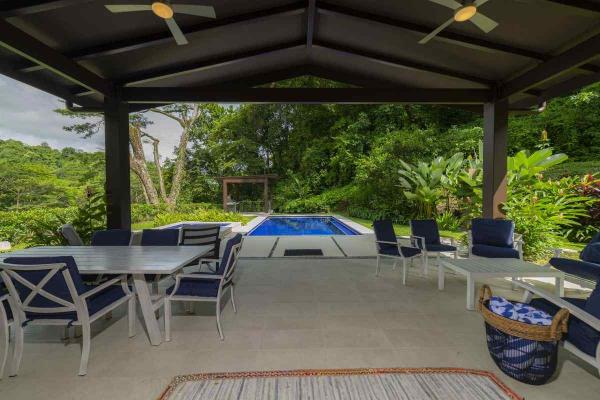 View of the outdoor living and dining area in the backyard at Casa Forest in Los Suenos